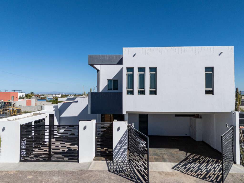 La Paz El Centenario Casa Cardenal is a contemporary residence in El Centenario, La Paz, offering a flexible layout designed for comfort, light, and everyday living. The first floor features two bedrooms and three full bathrooms, an open-concept kitchen and living area, and direct access to outdoor terraces--an appealing option for those seeking main-level living. The second floor hosts a spacious primary suite with a private balcony overlooking the desert landscape, plus additional space for a future bedroom or terrace. The ample backyard allows room for a pool, and select areas offer opportunities to personalize and add value. With a gated two-car garage and proximity to the ocean, Casa Cardenal presents both lifestyle and potential in a peaceful coastal setting. Offered at MXN – Casa Cardenal, La Paz, BS